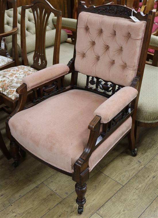 A Victorian carved walnut armchair covered in pink buttoned dralon